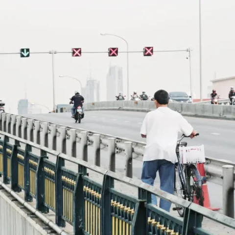 north korean people on road with bicycle