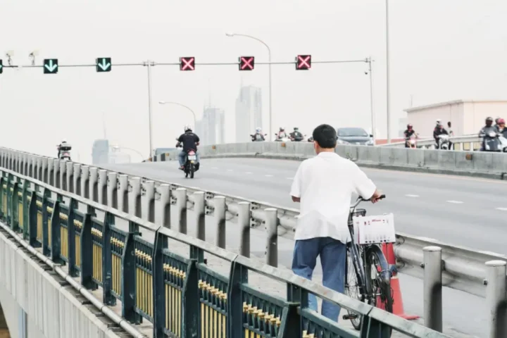 north korean people on road with bicycle