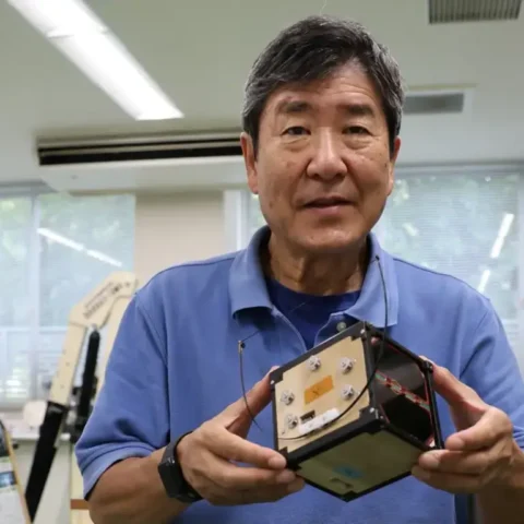 Former Japanese astronaut and Kyoto University professor Takao Doi holds a model of the wooden satellite LignoSat in his Kyoto lab during a Reuters interview.