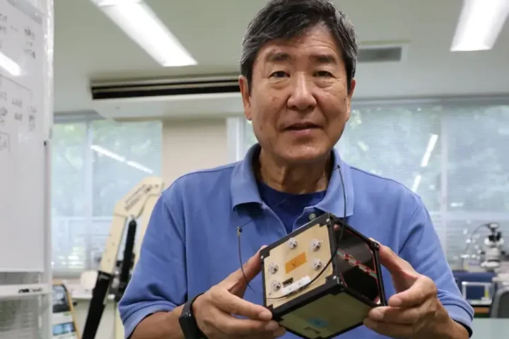 Former Japanese astronaut and Kyoto University professor Takao Doi holds a model of the wooden satellite LignoSat in his Kyoto lab during a Reuters interview.